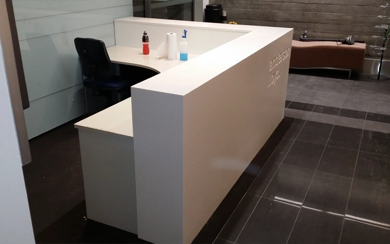 Architectural solid surface reception counter with curved sections bonded joints and integrated commercial details