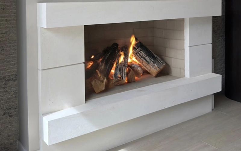 Close view of a fabricated stone hearth, mantel edge and fireplace surround joint