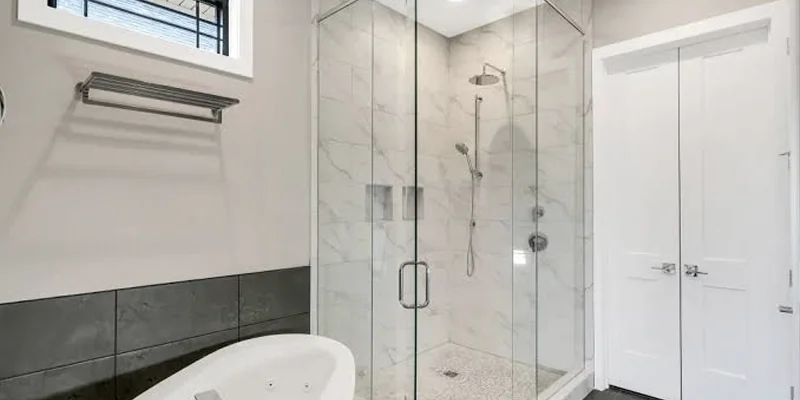 Frameless shower glass installed over a custom stone threshold