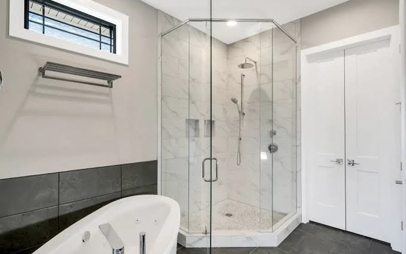 Frameless shower glass installed over a custom stone threshold