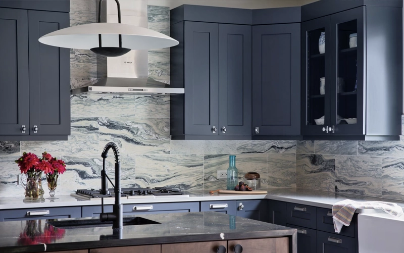 Large stone backsplash panel being positioned between kitchen countertops and cabinetry