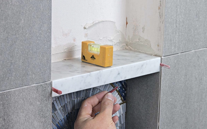 Waterproofed shower niche prepared before stone shelf and lining installation