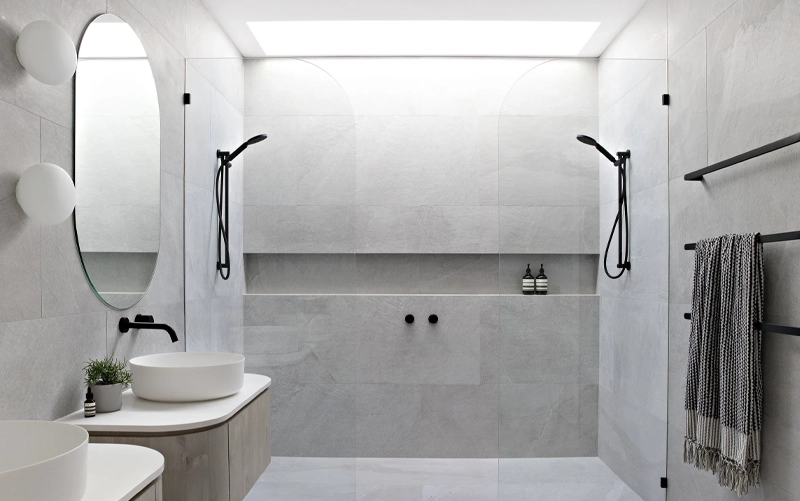 Stone shower niche placement with offset shelves and coordinated bathroom fixtures