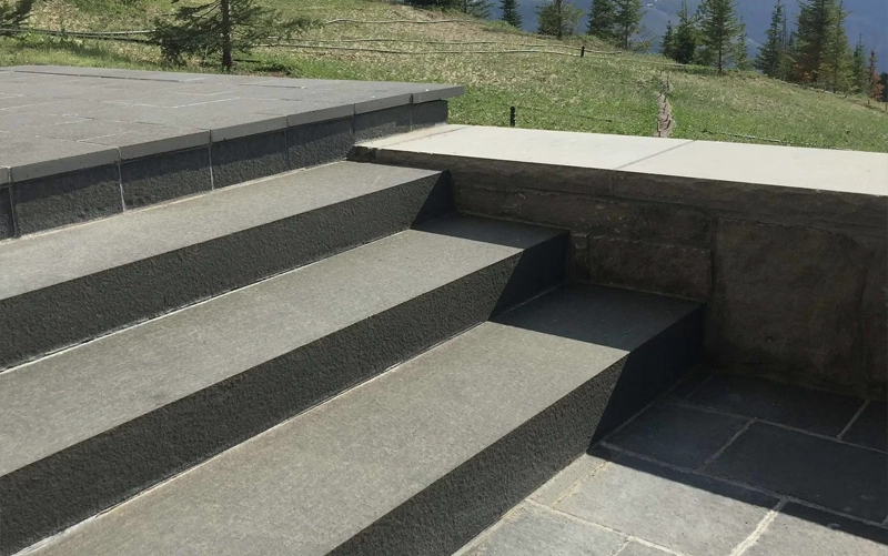 Fabricated stone stair treads and risers installed on a prepared staircase