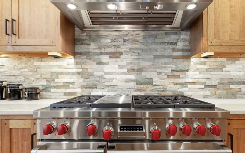 Stone slab kitchen backsplash being wiped with a soft non-abrasive cloth