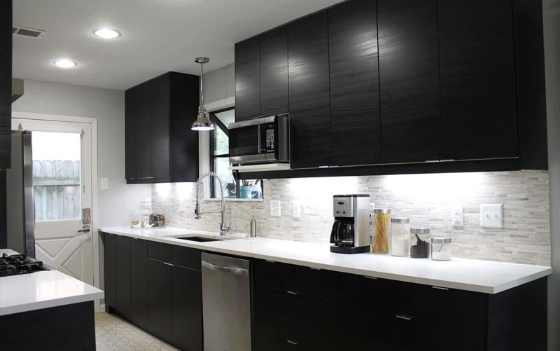 Black kitchen cabinets paired with a light stone countertop